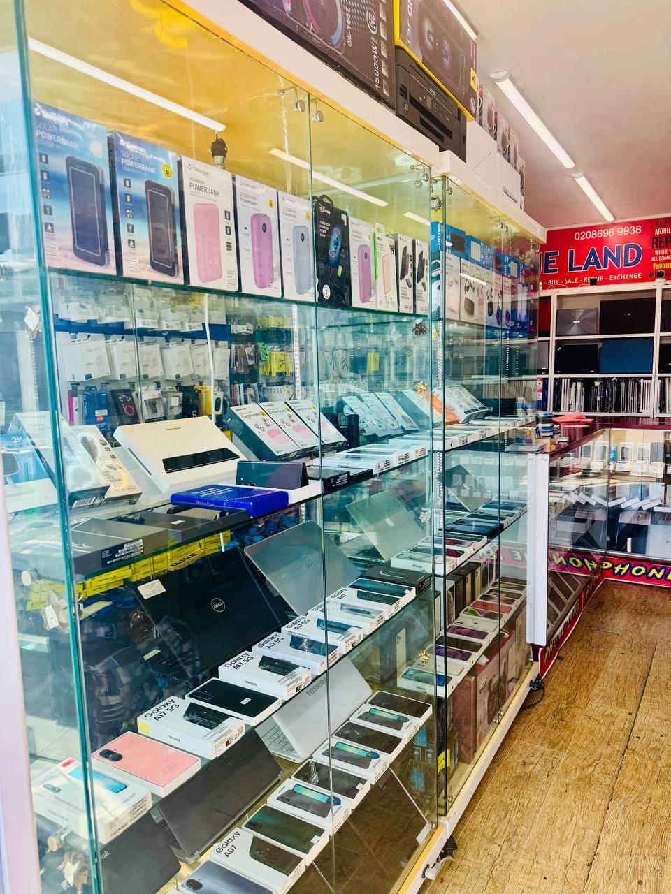 Inside PHONE LAND — shelves stocked with phones, laptops and accessories